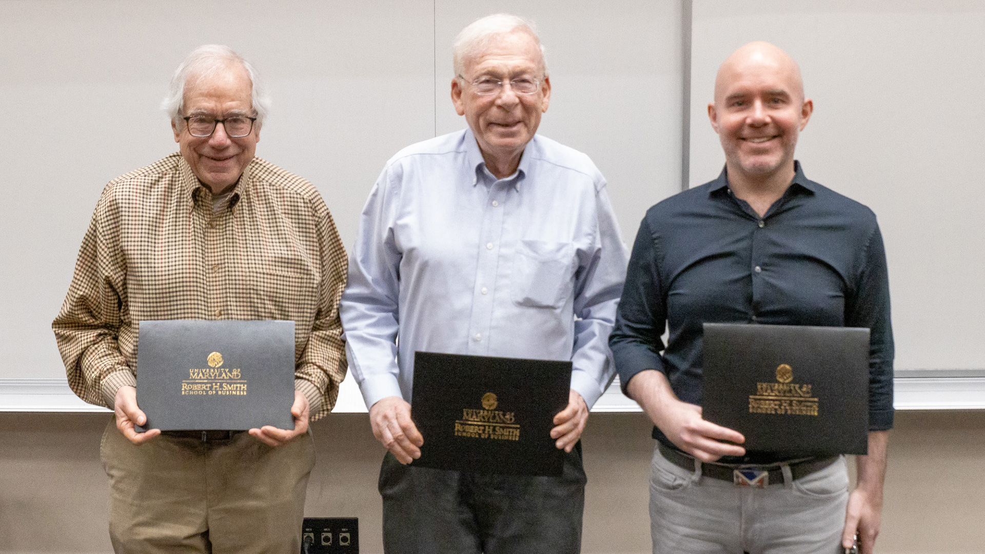 Thomas Corsi, David Kass, and Nicholas Seybert display their awards, recognizing their exceptional contributions to the Smith School community.