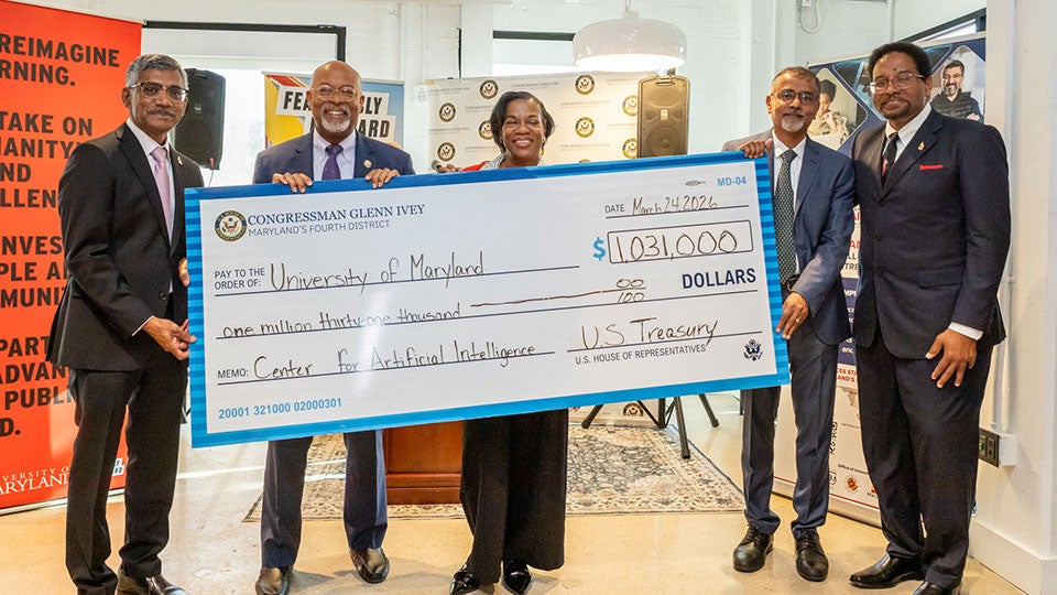  University of Maryland leaders and officials hold oversized $1.031 million federal grant check for AI small business initiative.