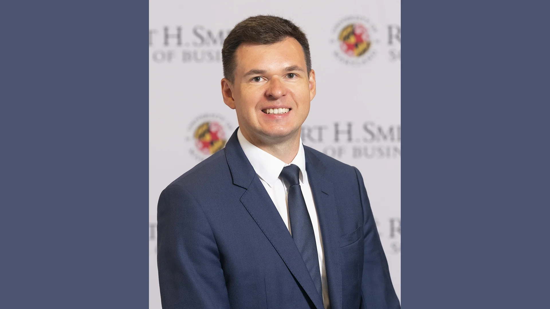 **Alt text:** Professional headshot of MBA student Anton Steshenko wearing a blue suit and tie, photographed in front of a University of Maryland Robert H. Smith School of Business backdrop.