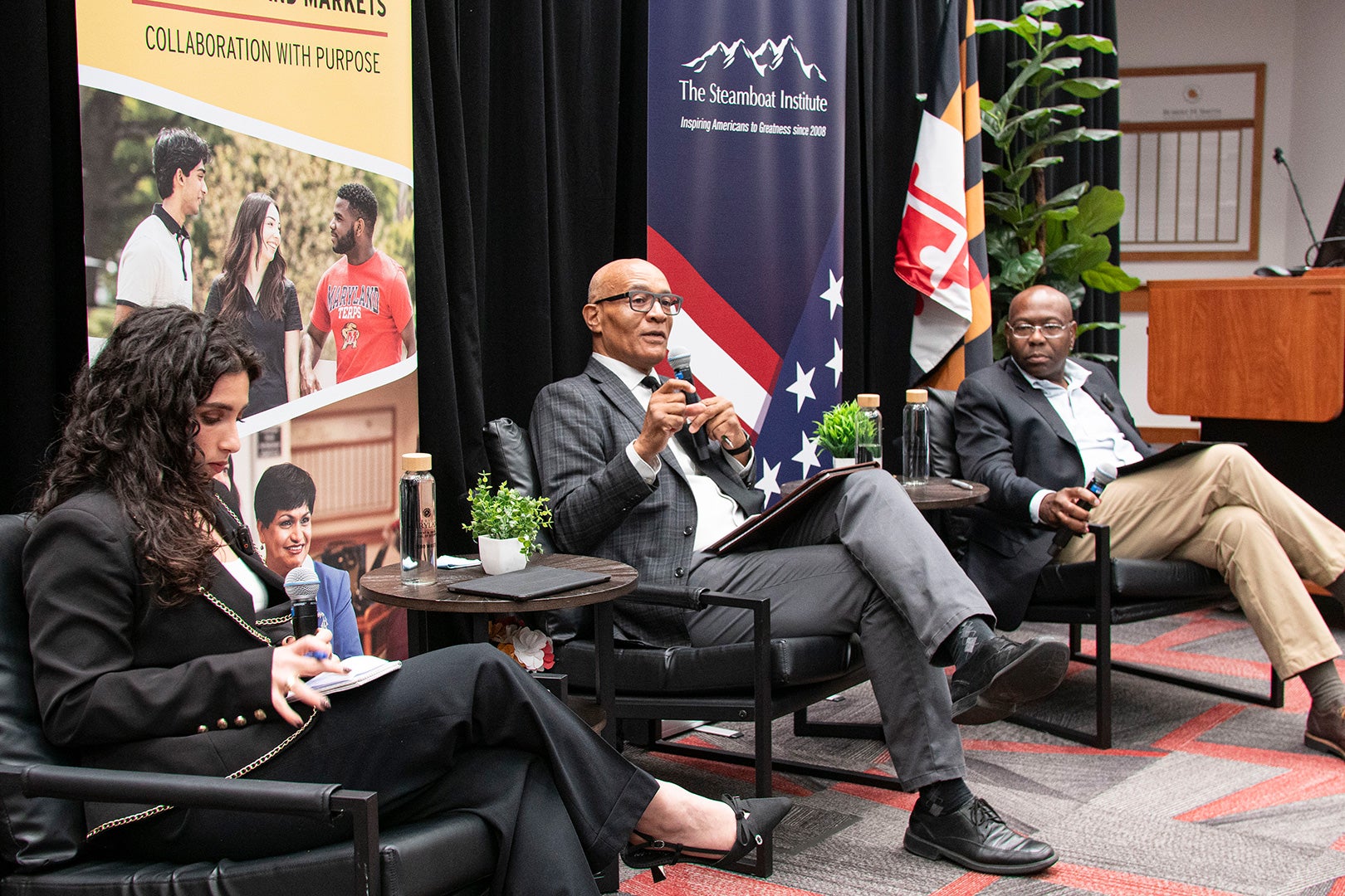 Three speakers seated on stage during a University of Maryland Smith School and Steamboat Institute panel discussion on DEI policies.
